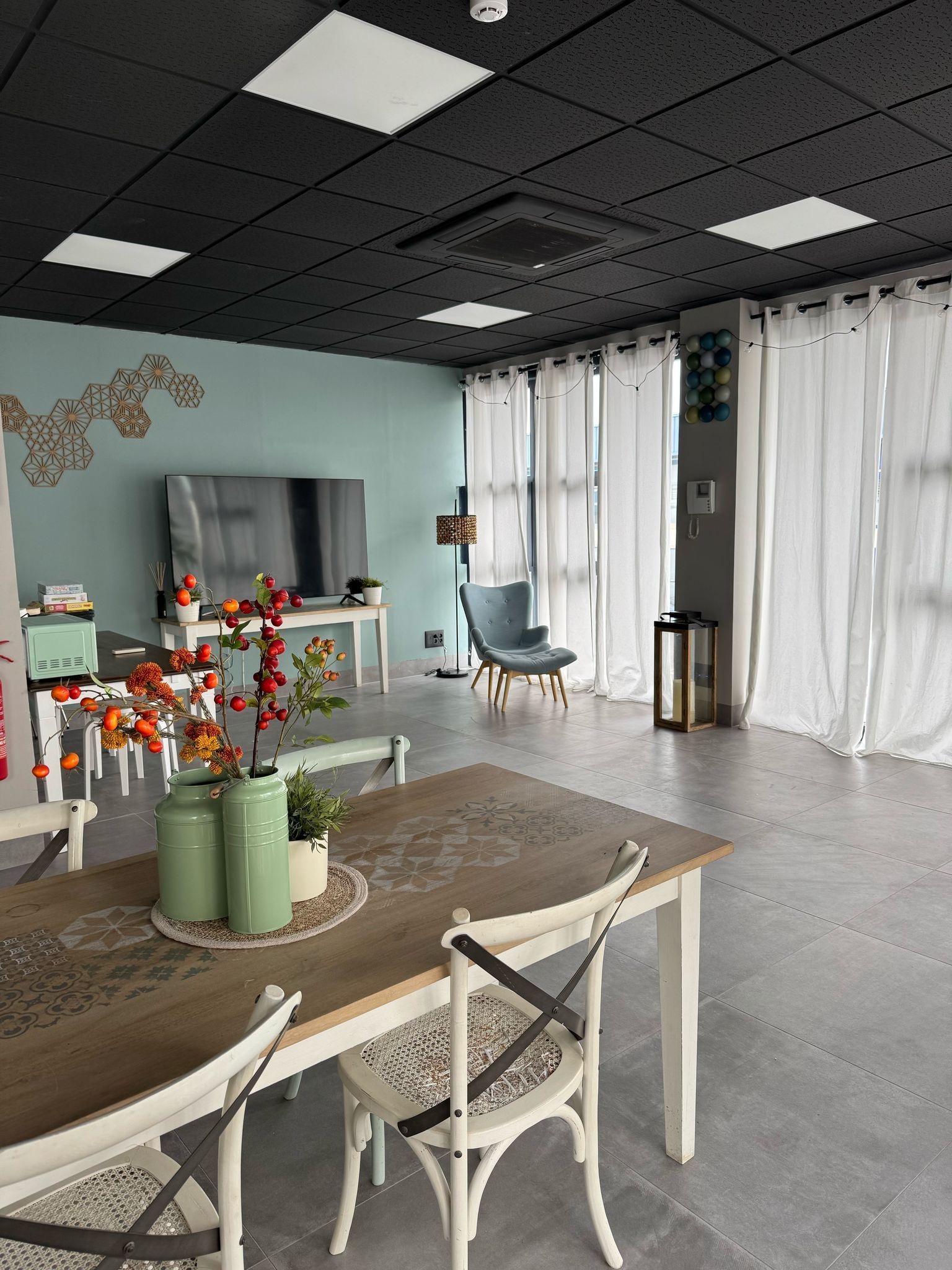 Una sala de estar con una mesa y sillas y un televisor.