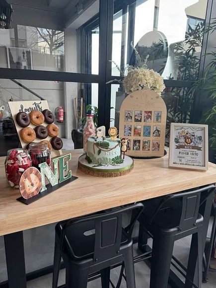 Una mesa de madera con un pastel y donas encima.