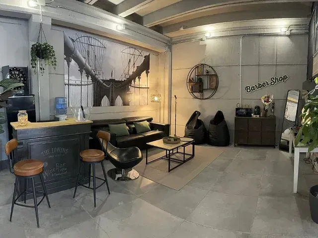Una sala de estar con sofá, mesa, sillas y un bar.