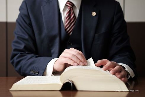 Person blättert durch ein dickes Buch