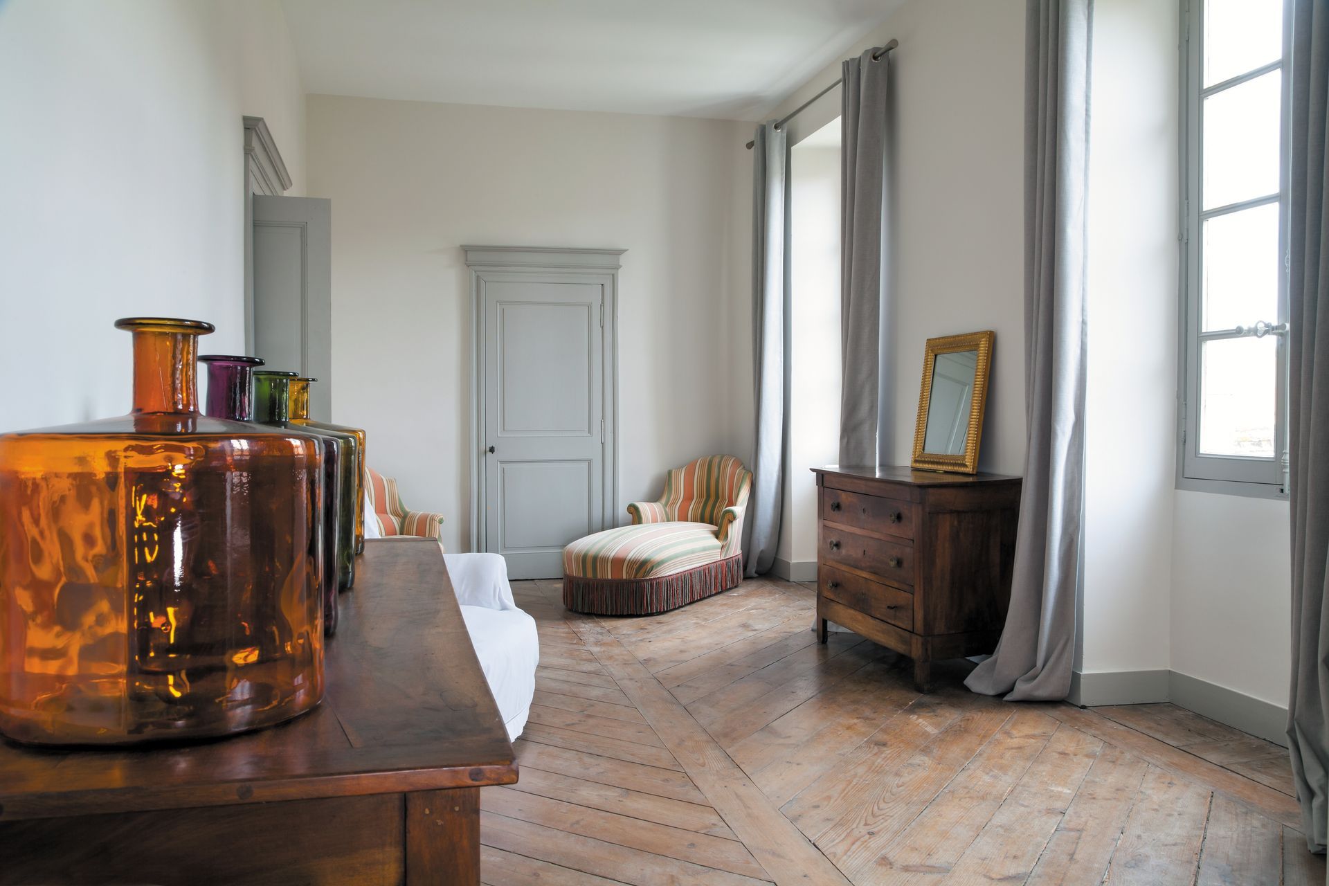 Main tenant une maison miniature examinée à la loupe