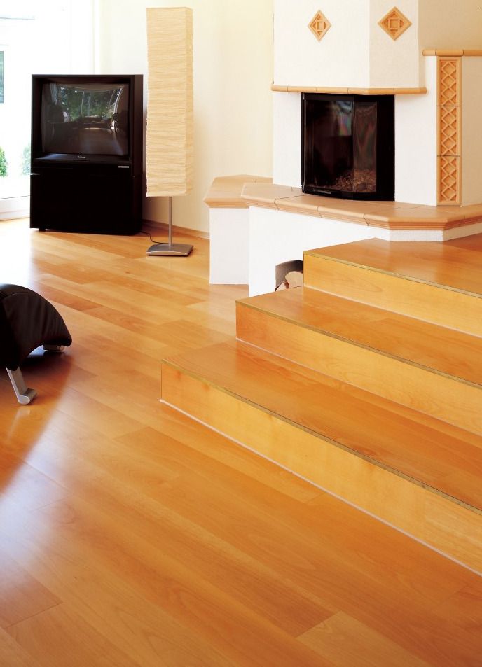 Ein Wohnzimmer mit Parkettboden und Treppe sowie einem Kamin