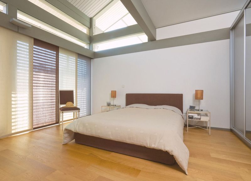 Ein Schlafzimmer mit großem Bett und vielen Fenstern