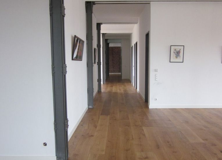 Ein langer Flur mit Holzböden und weißen Wänden
