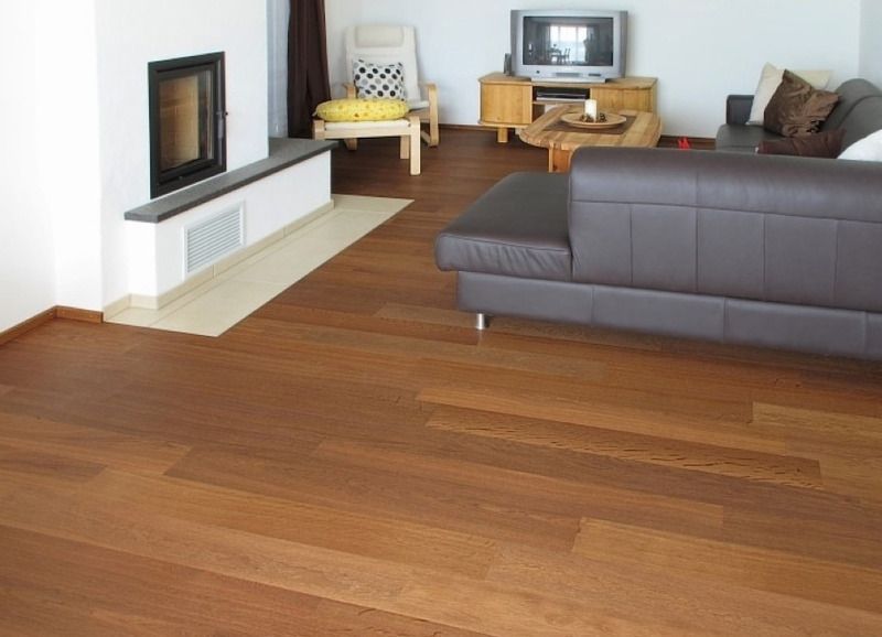 Ein Wohnzimmer mit einer Couch, einem Sessel, einem Fernseher und einem Kamin