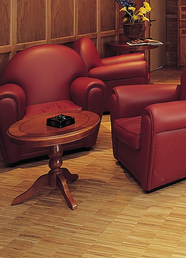 Ein Wohnzimmer mit roten Lederstühlen und einem Holztisch