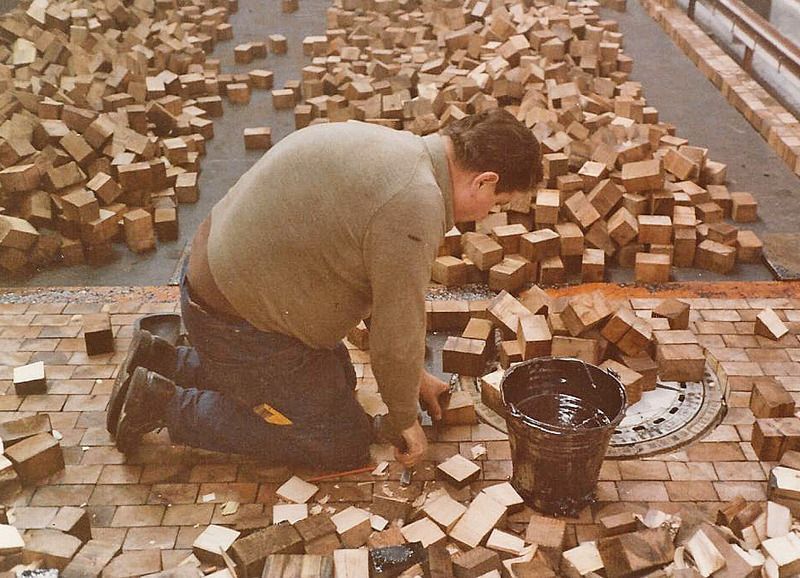 Ein Mann kniet vor einem Ziegelhaufen