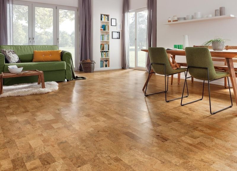 Ein Wohnzimmer mit Couch, Tisch und Stühlen und Korkboden.