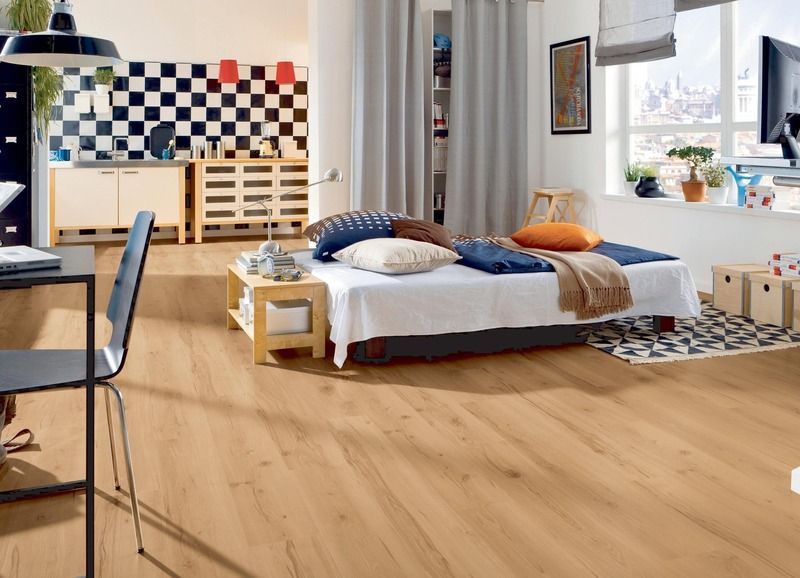 In der Mitte des Zimmers steht ein Bett mit Holzboden.