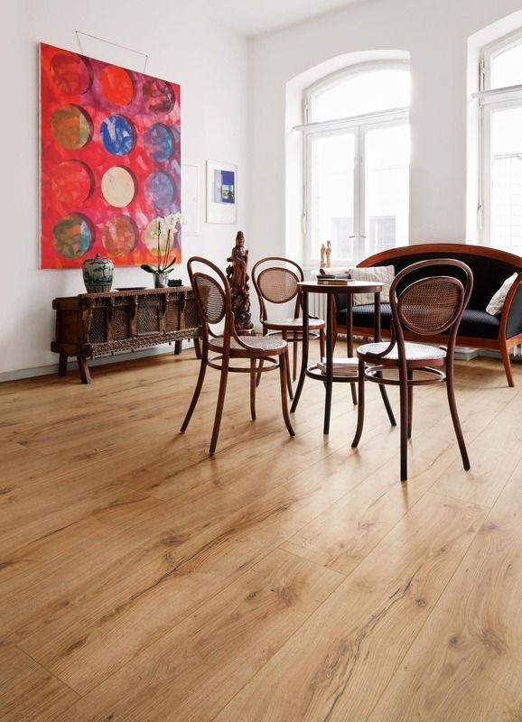 Ein Wohnzimmer mit einem Tisch und Stühlen und einem Gemälde an der Wand.