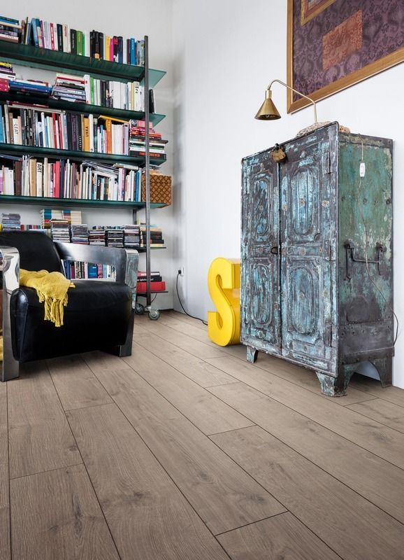 Ein Wohnzimmer mit einem Stuhl, einem Bücherregal und einem gelben Buchstaben S