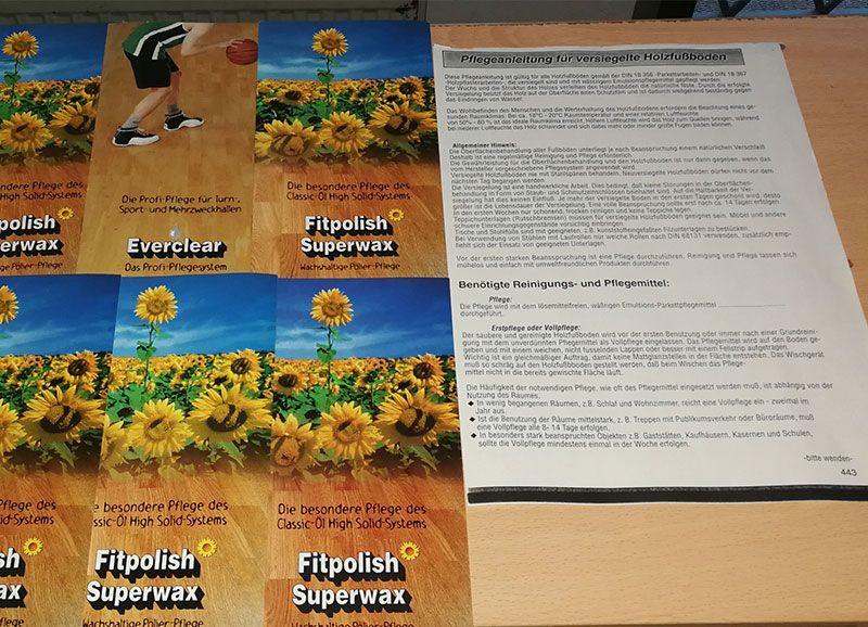 Ein Stapel Papiere auf einem Tisch, auf denen Fitpolish Superwax steht