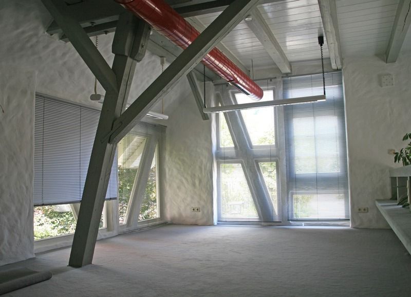 Ein leerer Raum mit einem roten Rohr, das von der Decke hängt