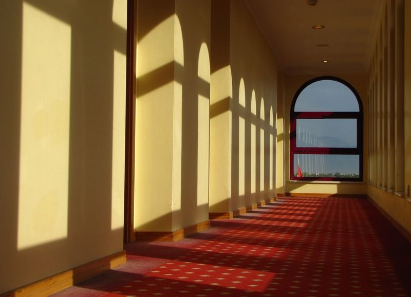 Ein Flur mit Bogenfenstern und einem roten Teppich