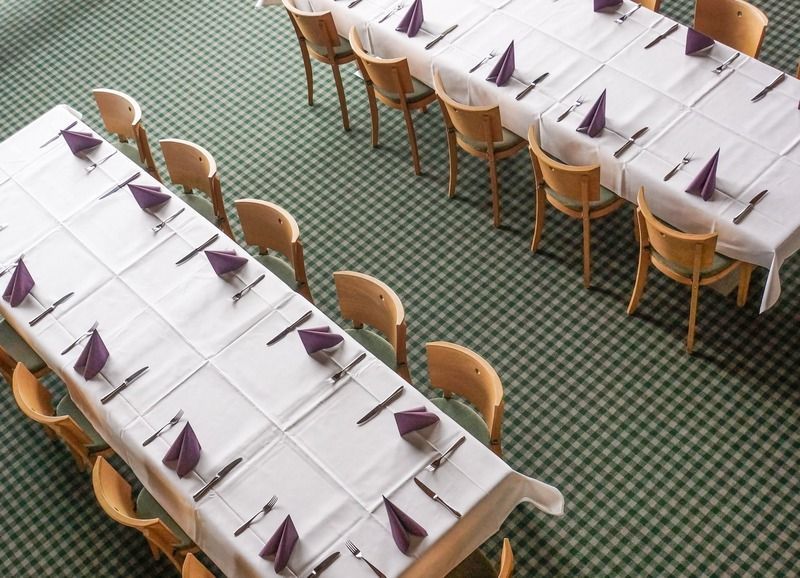 Ein langer Tisch mit lila Servietten und Besteck darauf