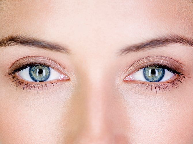 Primer plano de unos ojos azules en un rostro pálido, mirando fijamente al frente.