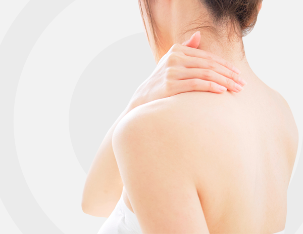 Persona sujetándose el cuello y el hombro, aparentemente con dolor de cuello sobre un fondo claro.