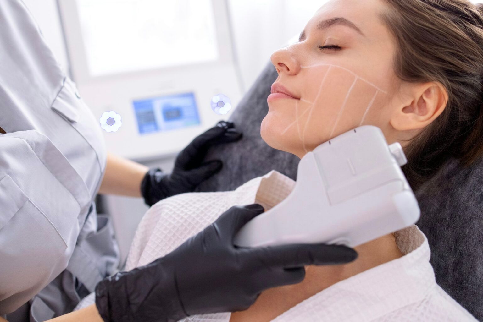 Esteticista utilizando un dispositivo manual en la mandíbula de una mujer durante un tratamiento facial.