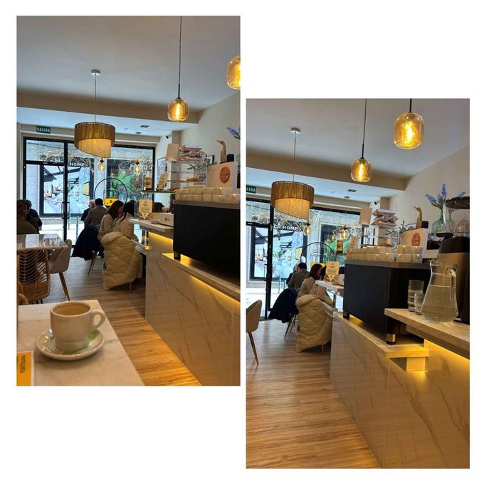 Interior acogedor de una cafetería con luces colgantes, clientes junto al mostrador y una taza de café en primer plano.