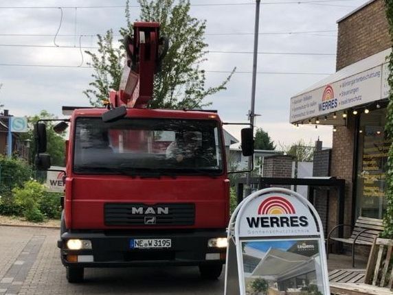 Mann hämmert gegen ein Teil einer Markise in einer Werkstatt