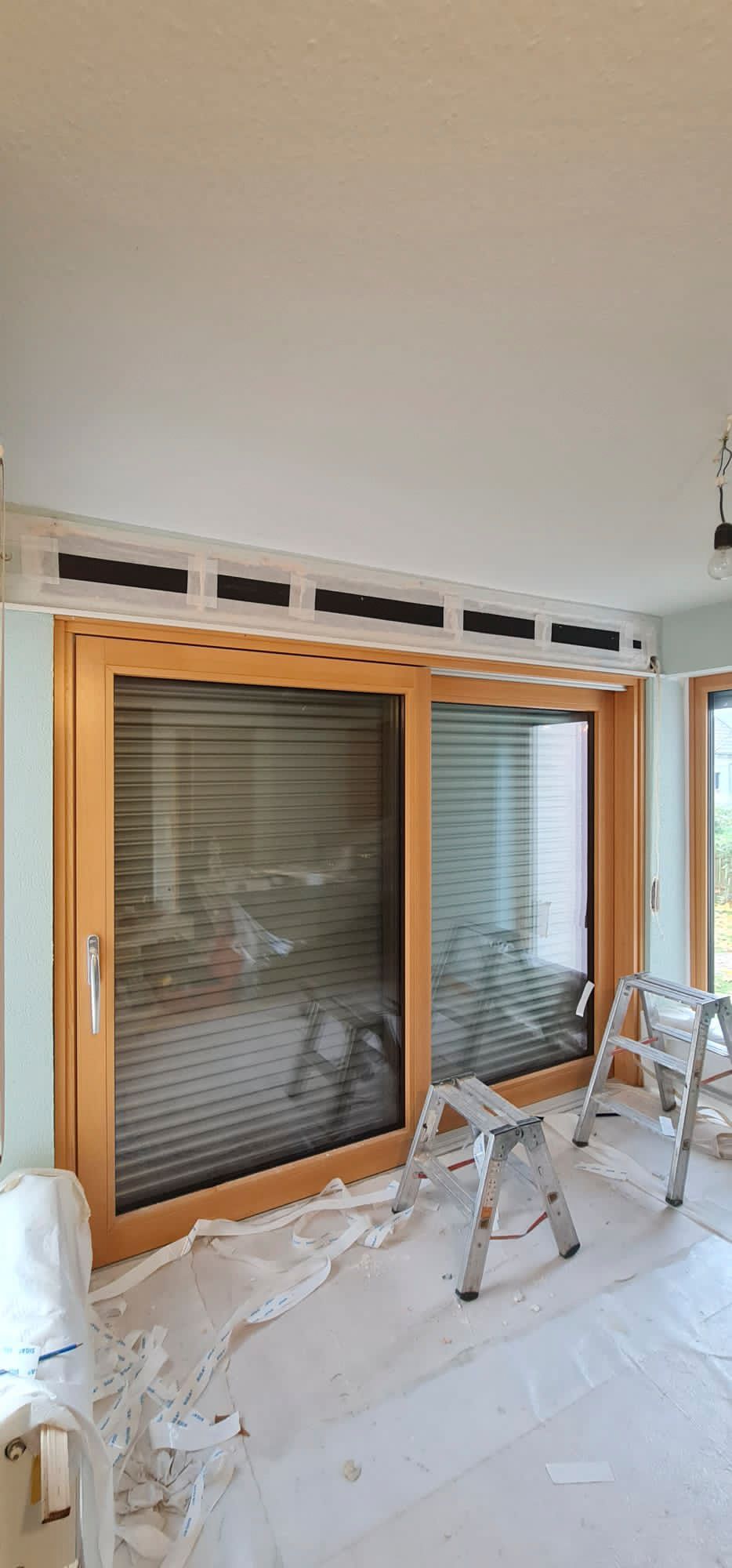 Ein Raum mit einem großen Fenster und einer Leiter darin.