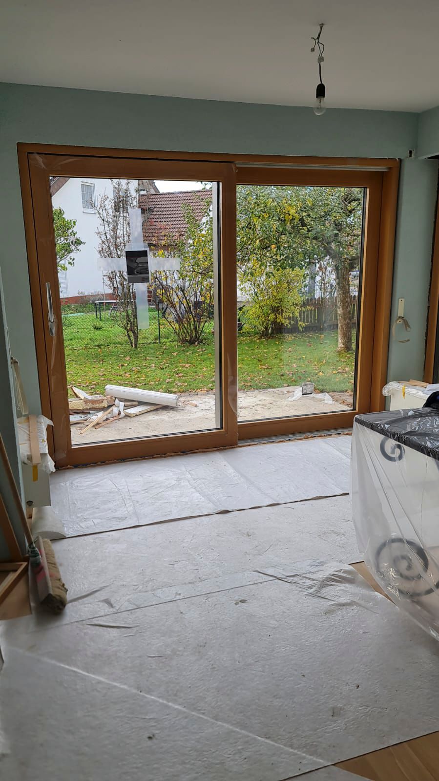 Ein Raum mit einer Glasschiebetür, die zu einem Hinterhof führt.