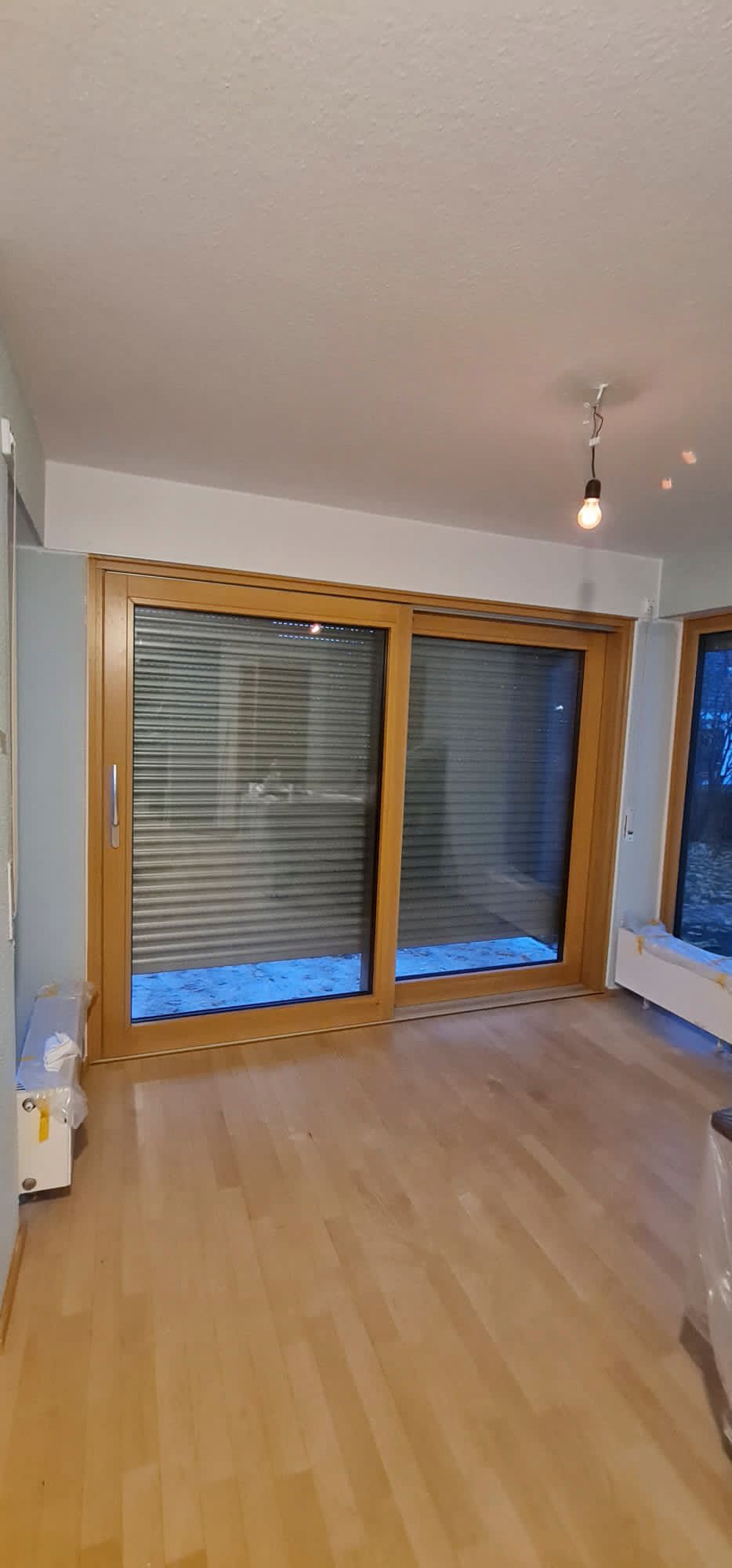 Ein Wohnzimmer mit Glasschiebetüren und Holzboden.