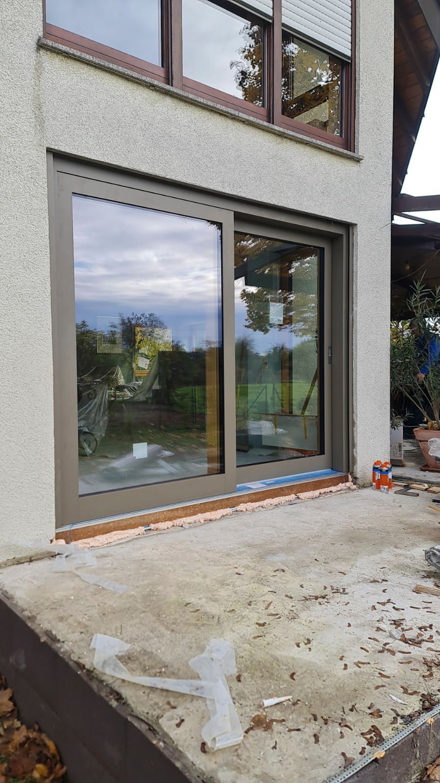 An der Seite eines Hauses wird eine Glasschiebetür eingebaut.