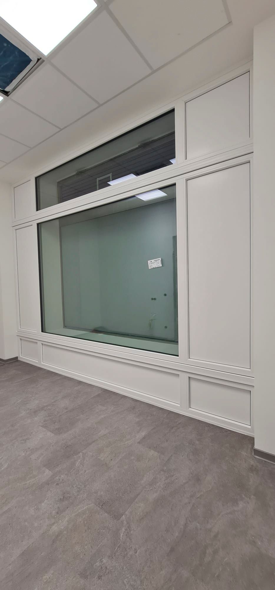 Ein leerer Raum mit einem großen Fenster an der Wand.