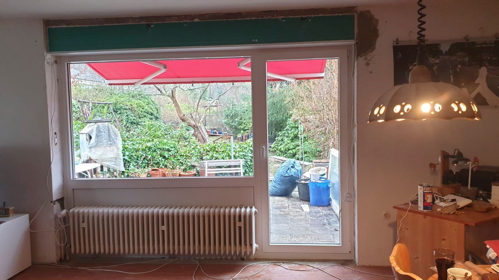 Ein Wohnzimmer mit großem Fenster und roter Markise.