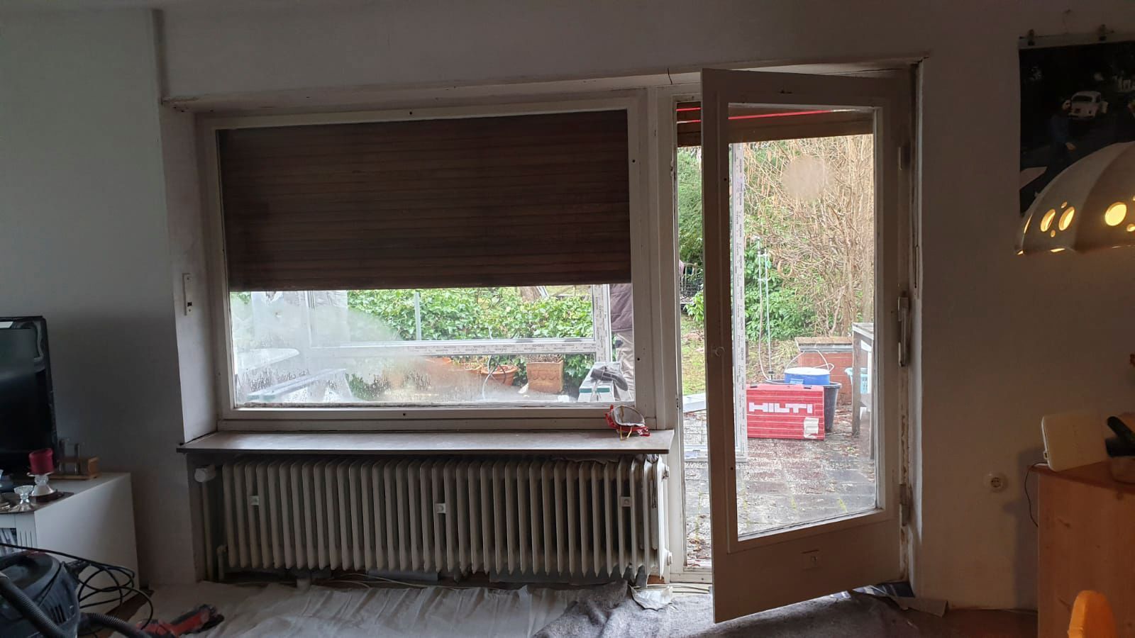 Ein Wohnzimmer mit einem großen Fenster und einer Glasschiebetür.