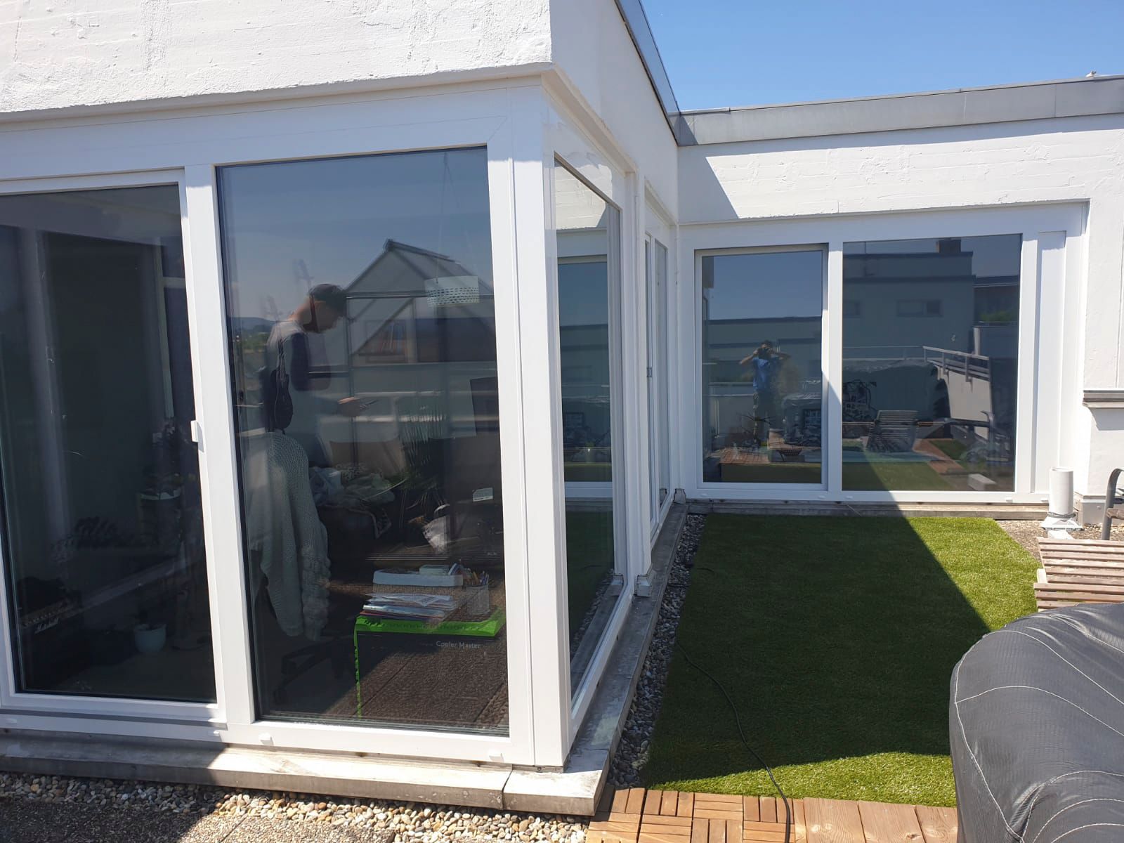 Ein Haus mit vielen Fenstern und einer Wiese davor