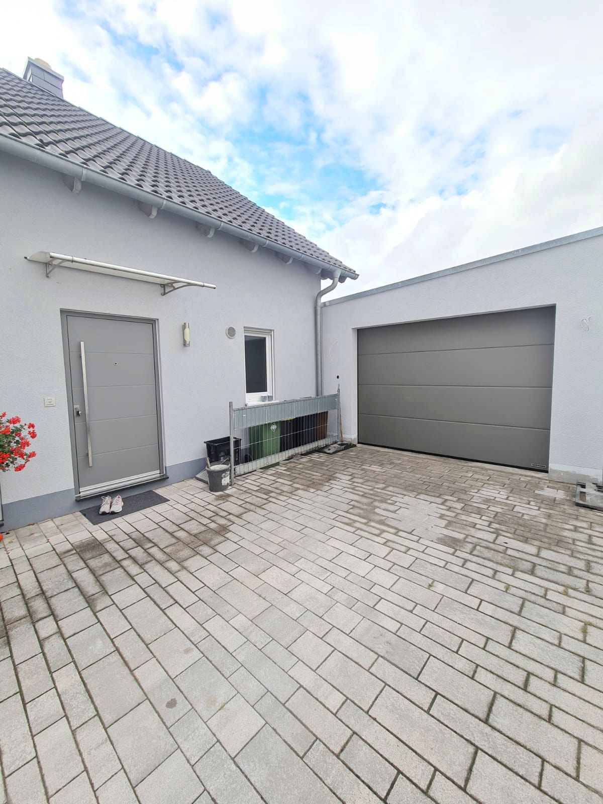 Ein Haus mit einer Garage und einer gepflasterten Auffahrt davor.