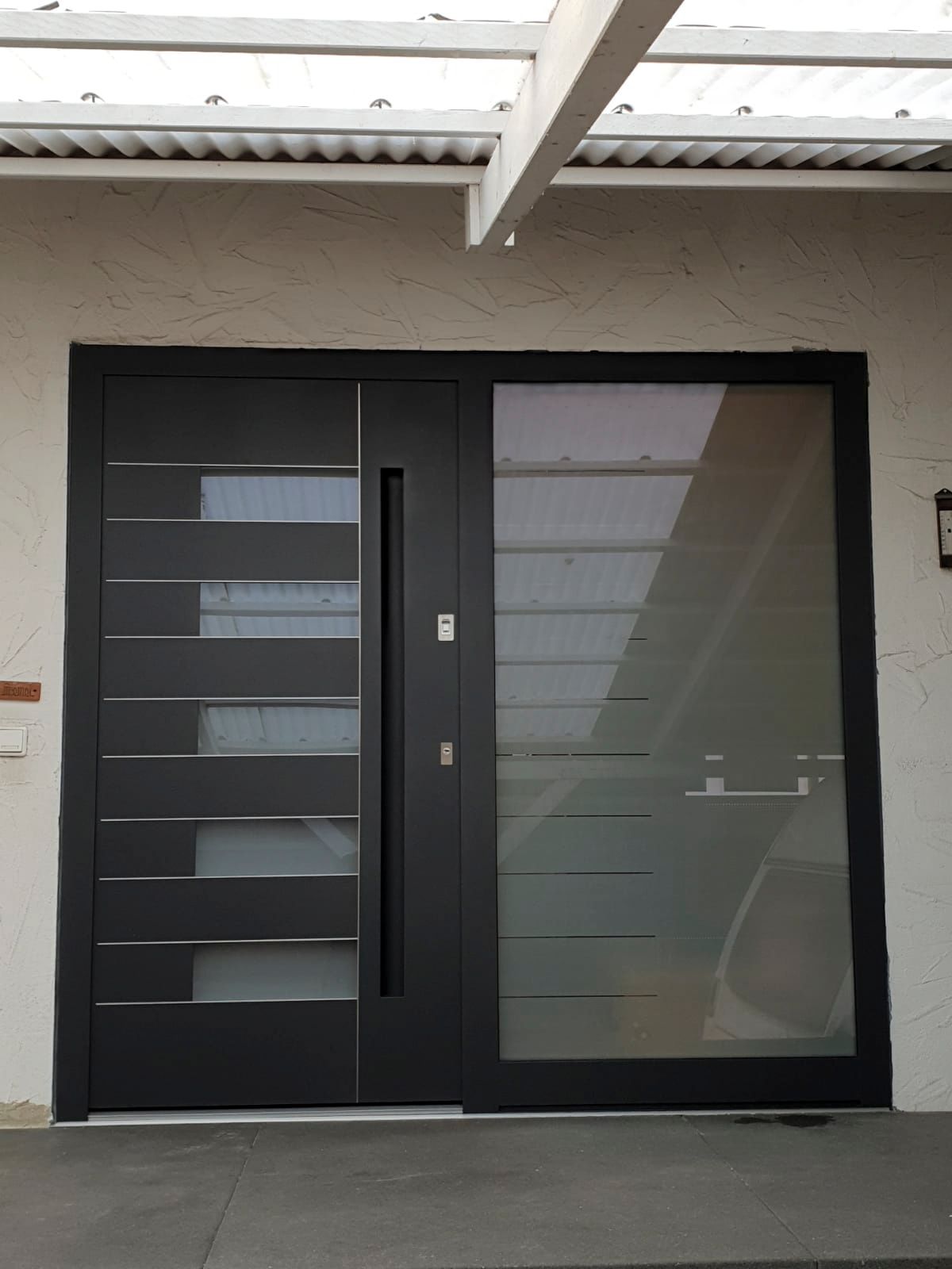 Eine schwarze Tür mit einer Schiebetür aus klarem Glas