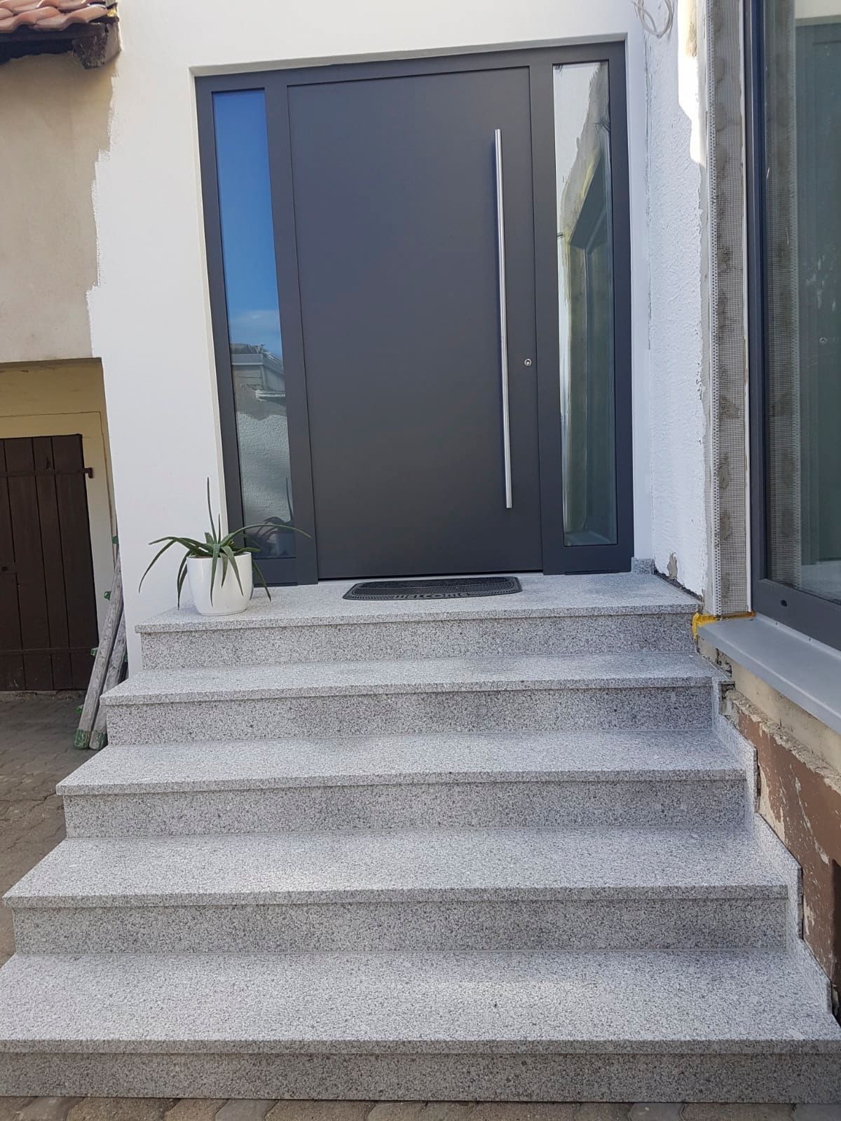 Eine Treppe, die zu einer Haustür hinaufführt.