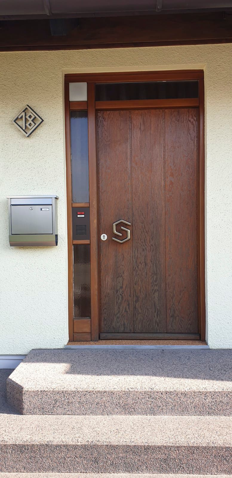 Die Haustür eines Hauses mit Treppe und Briefkasten.