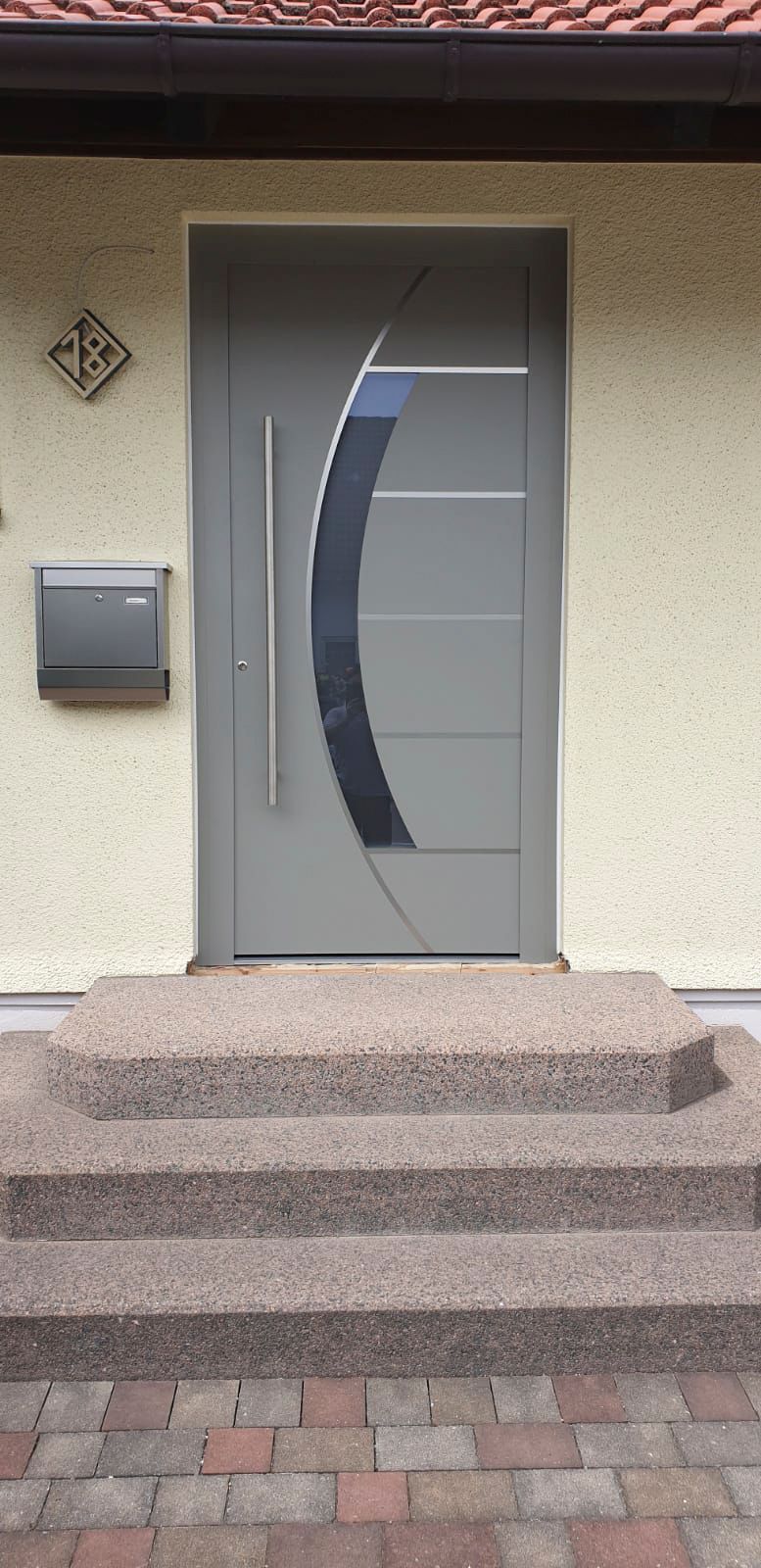 Die Haustür eines Hauses mit Treppe und Briefkasten.