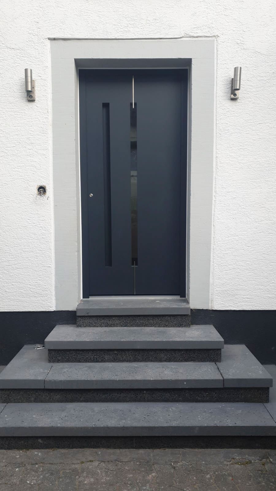 Die Eingangstür eines Hauses, zu der eine Treppe hinaufführt.