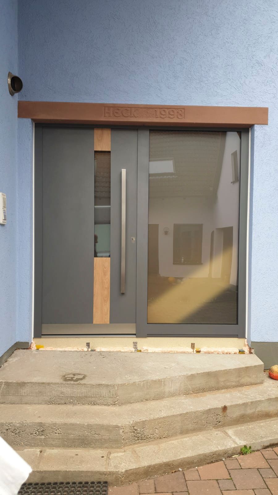 Ein blaues Gebäude mit einer grauen Tür und Treppe