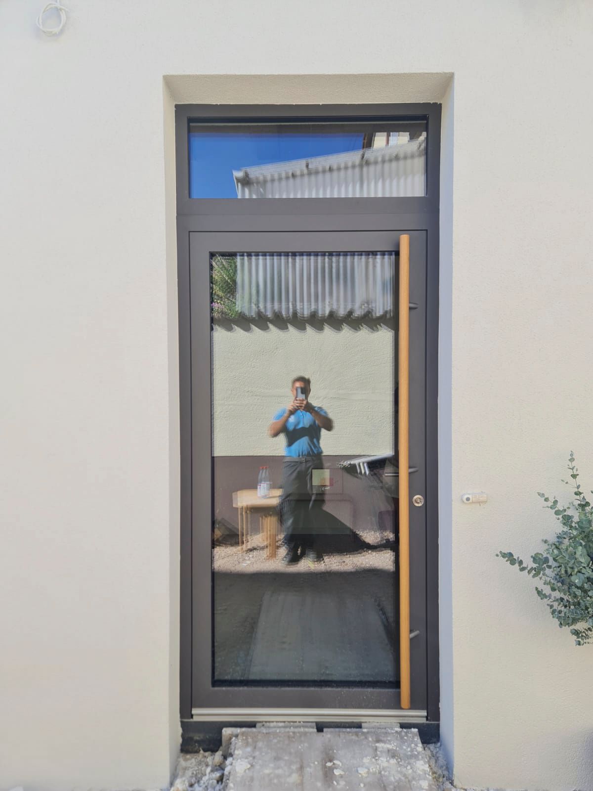 Ein Mann macht in einem Hauseingang ein Foto von sich.