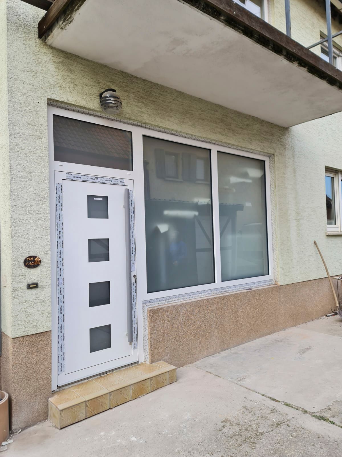 An der Seite eines Gebäudes befindet sich eine weiße Tür mit Quadraten.
