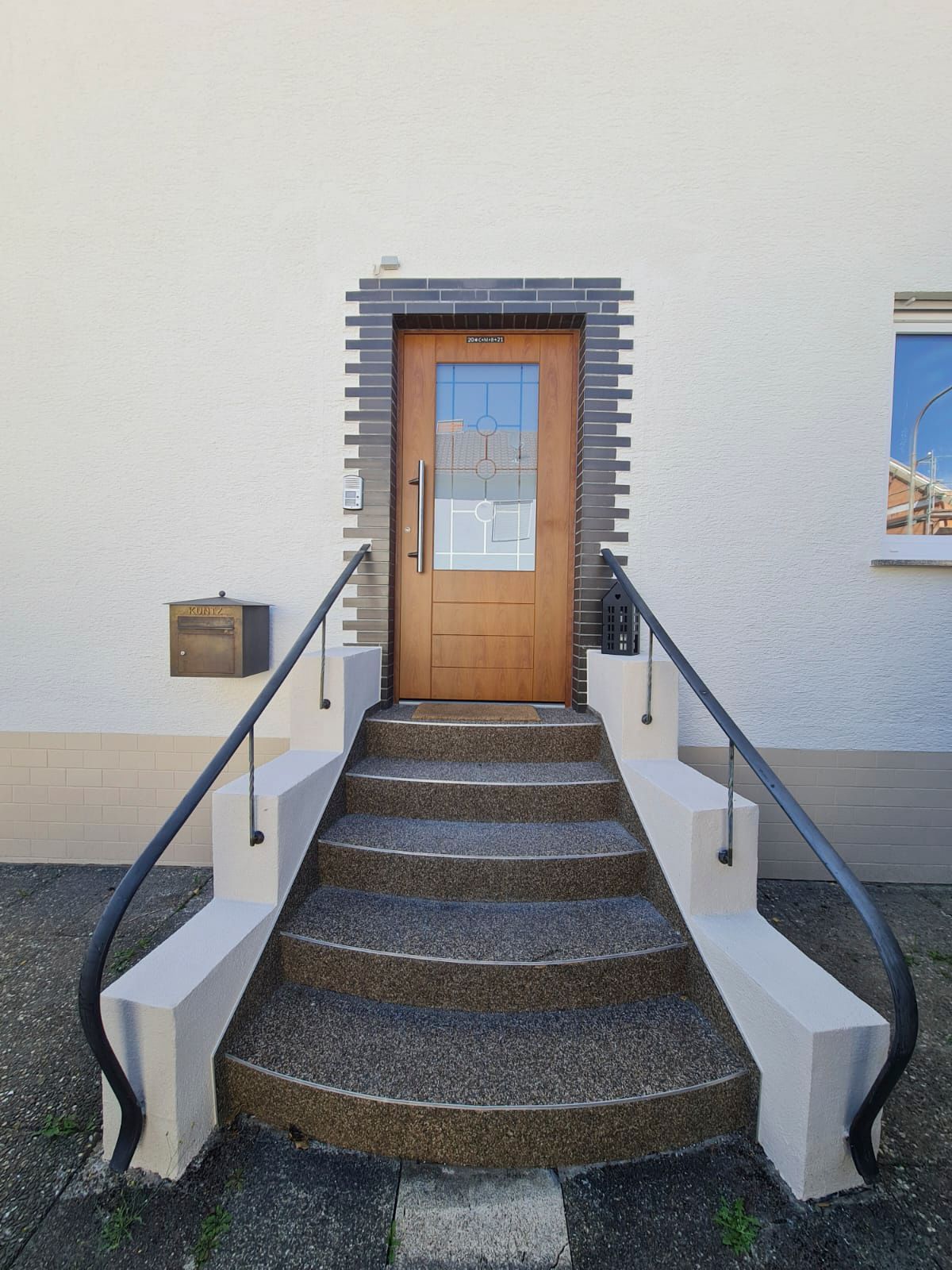 Ein weißes Gebäude mit einer Holztür und einer Treppe, die dorthin führt