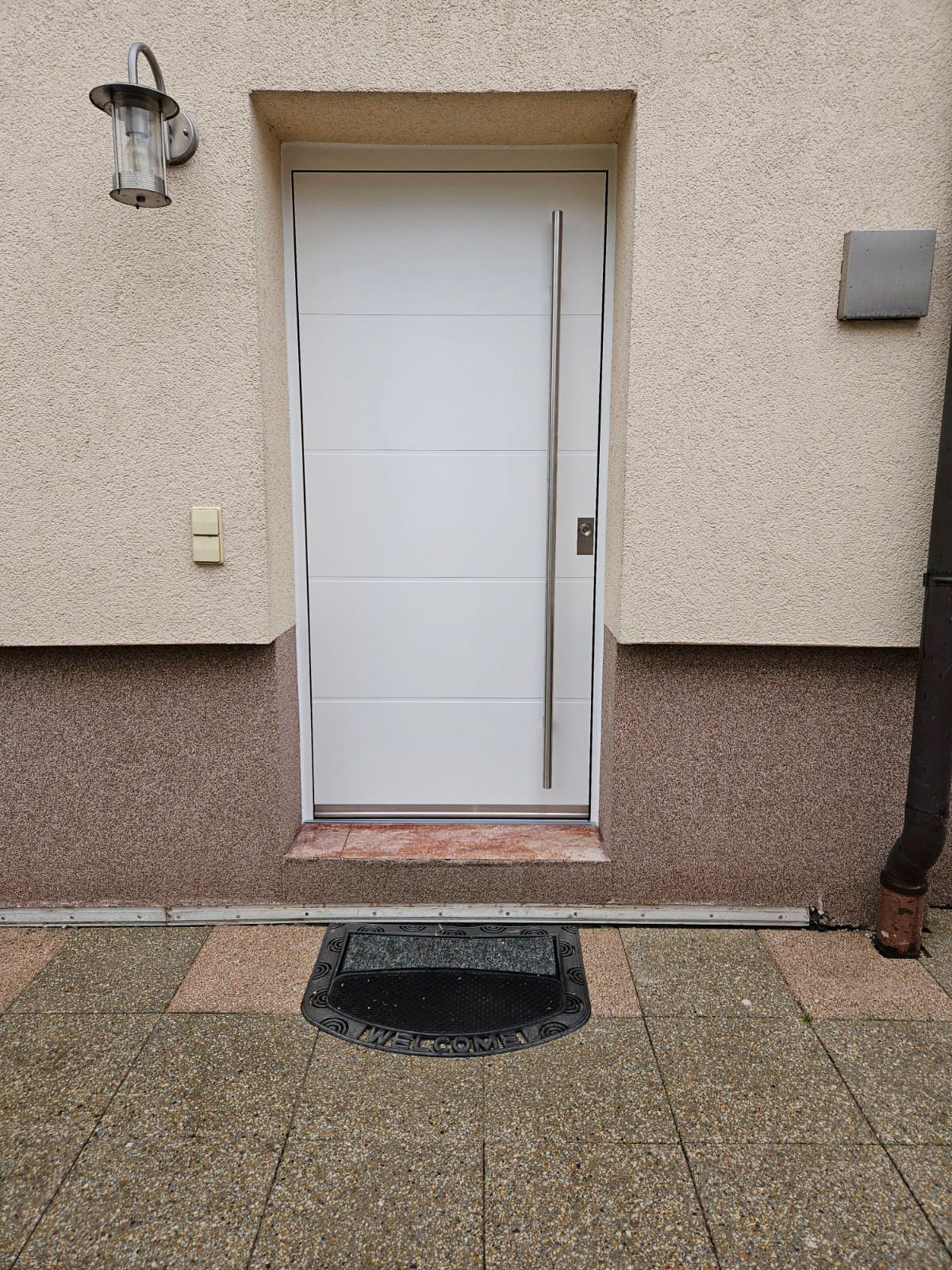 An der Seite eines Gebäudes ist eine weiße Tür.