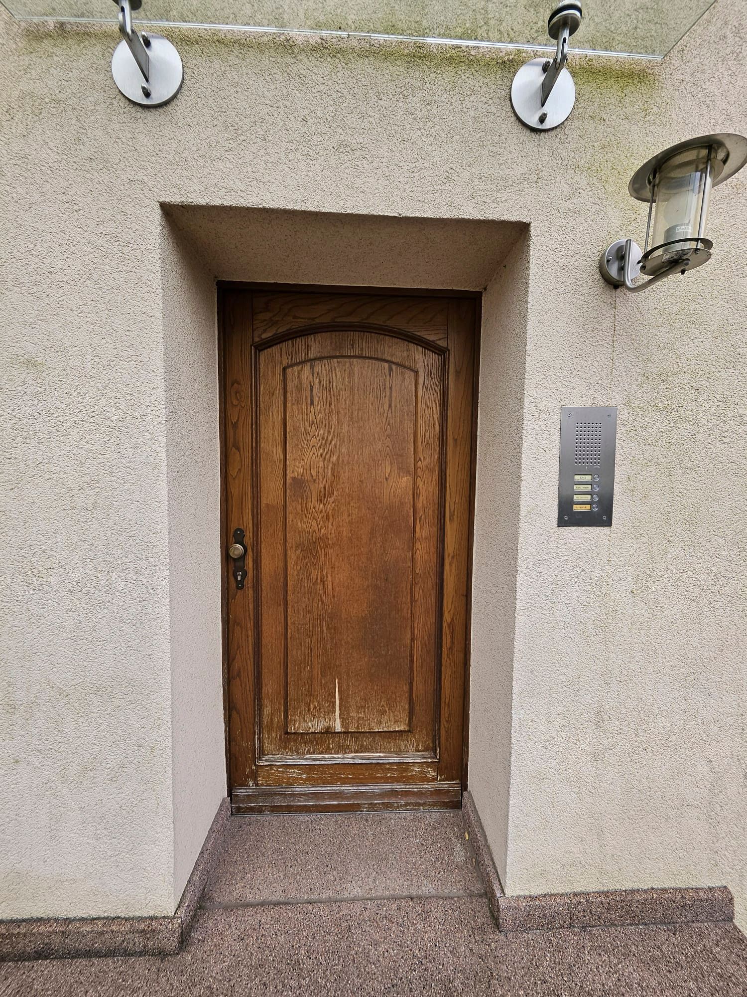 An der Seite eines Gebäudes befindet sich eine Holztür.