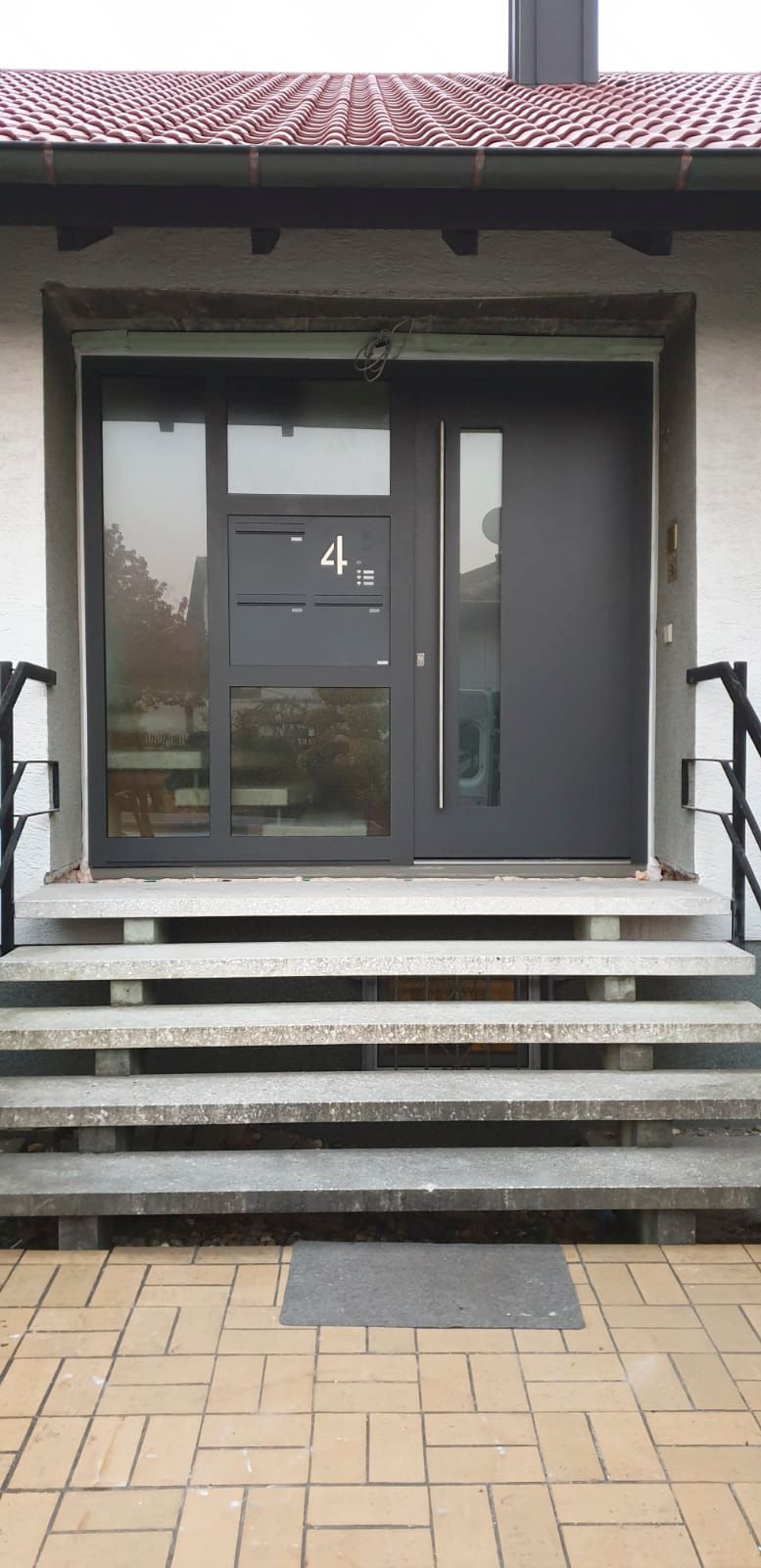 Die Eingangstür eines Hauses, zu der eine Treppe hinaufführt.