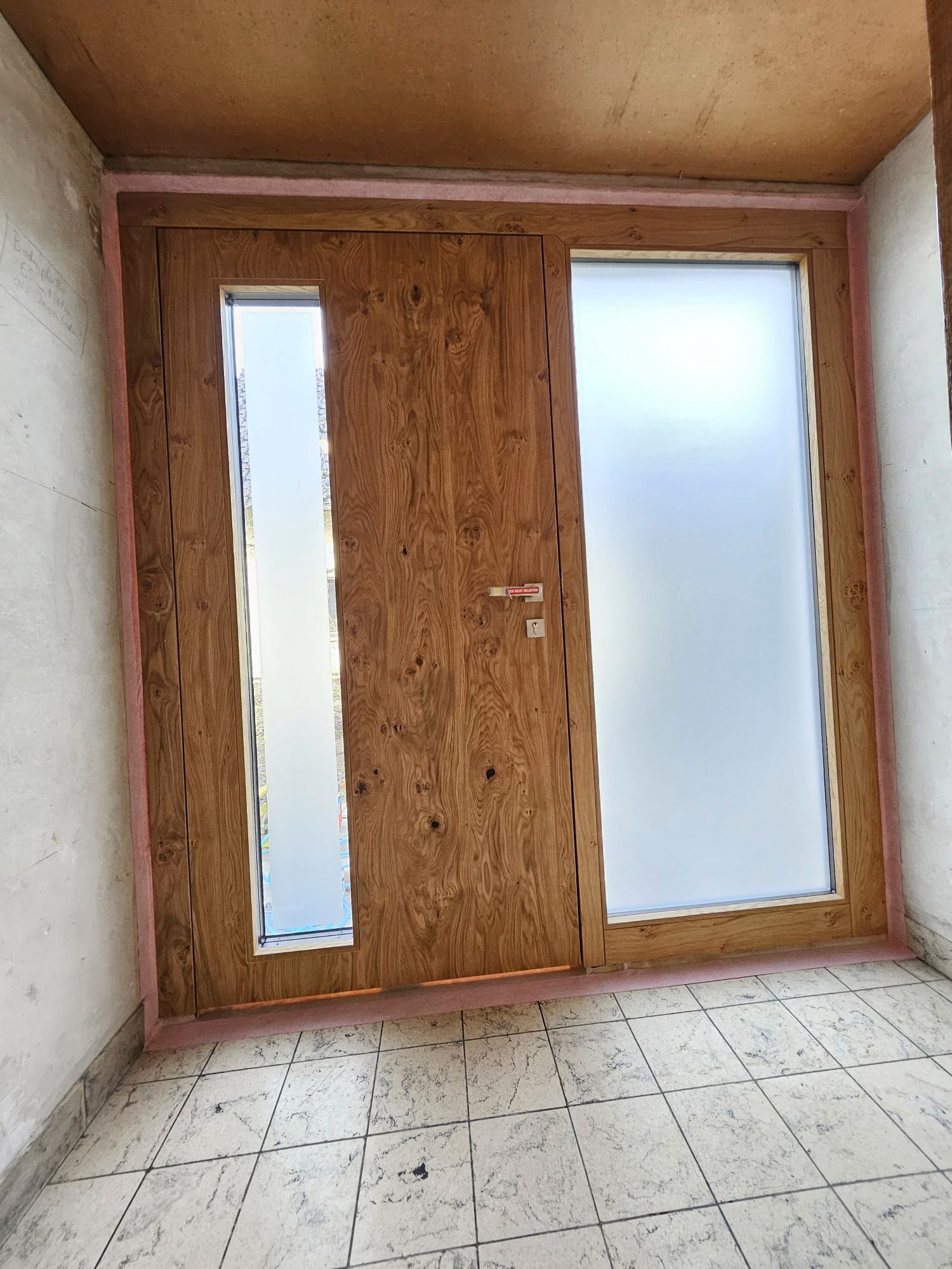 Ein Raum mit einer Holztür und einem weißen Fliesenboden.