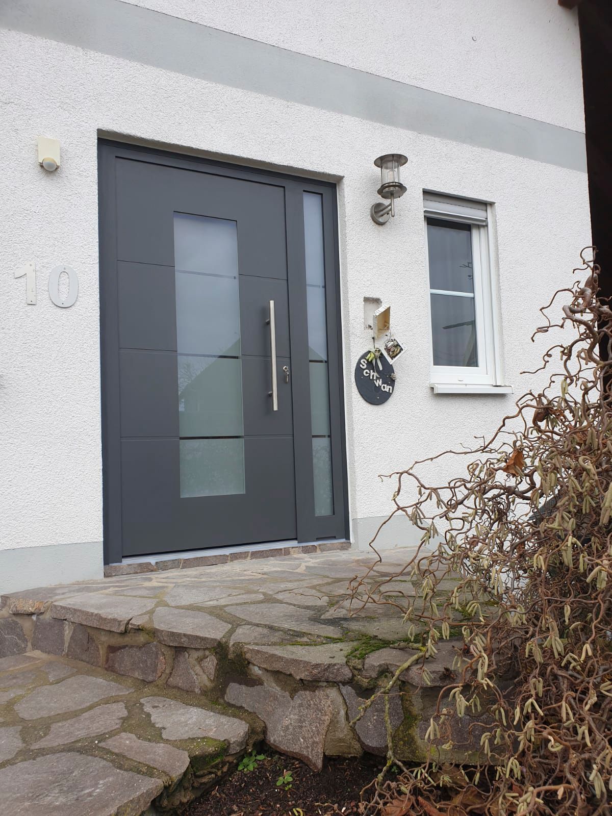 Ein weißes Haus mit einer schwarzen Tür und einem Fenster