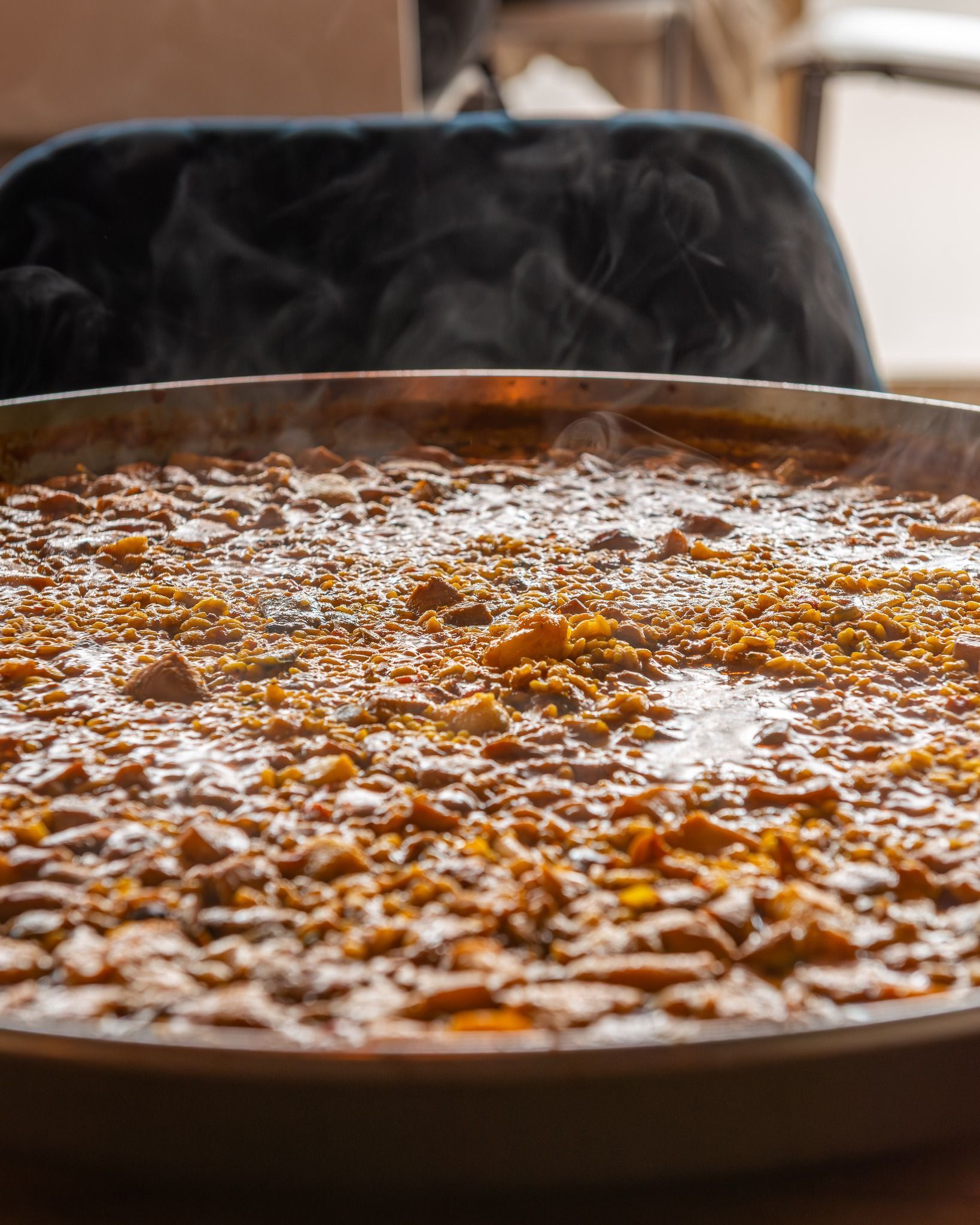Una olla con comida de la que sale vapor está sobre una mesa.