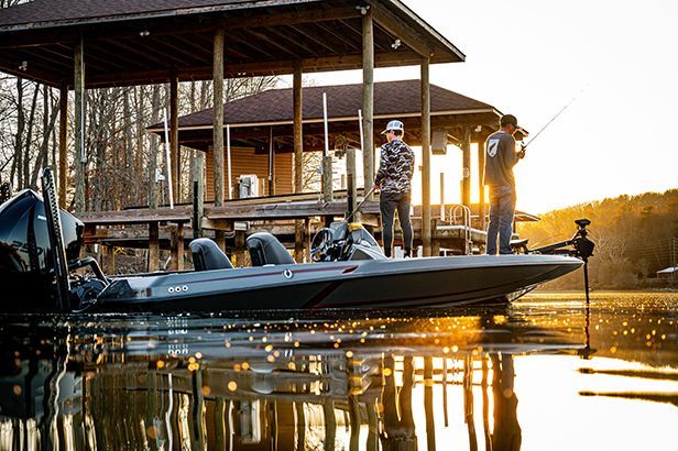 Two men are fishing from a boat on a lake.