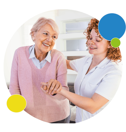 Une femme âgée souriante tient la main d'une infirmière